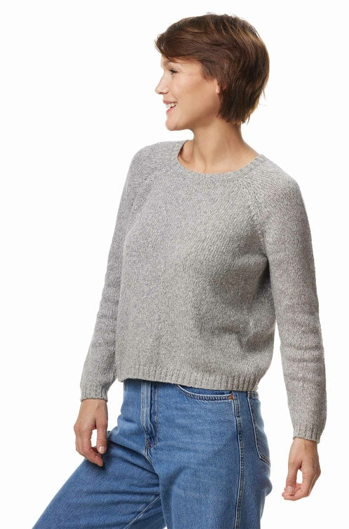 Seitenansicht einer Frau die einen Wollpullover in der Farbe Grau-meliert trägt