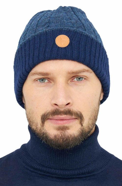 Portraitansicht eines Mannes der die wendbare Strickmütze SUAVE aus Alpaka in den Farben Dunkelblau Blau trägt