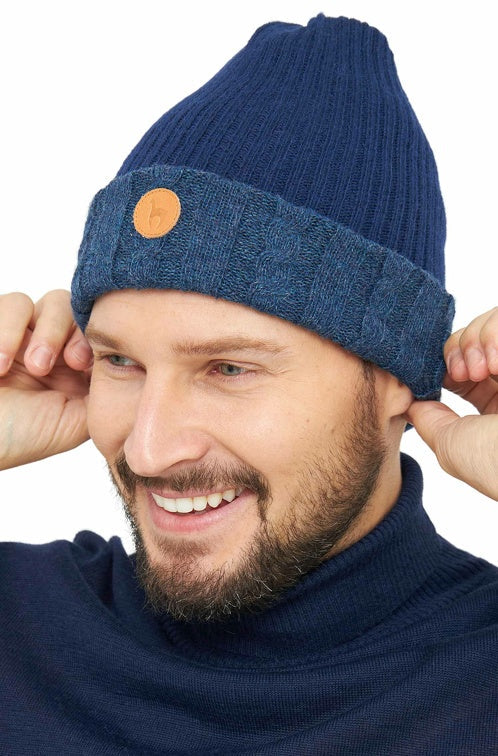 Halbprofilansicht eines Mannes der die wendbare Strickmütze SUAVE aus Alpaka in den Farben Dunkelblau Blau trägt