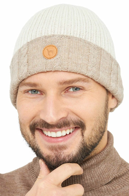 Portraitansicht eines Mannes der die wendbare Strickmütze SUAVE aus Alpaka in den Farben Sand Ecru trägt