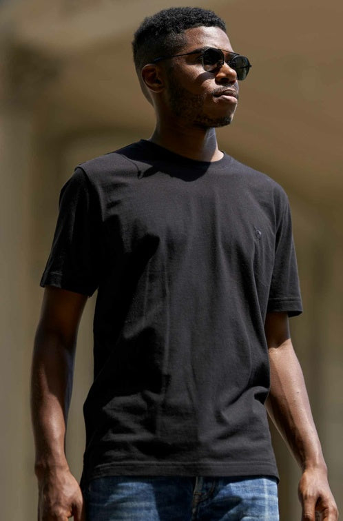 Frontansicht eines Mannes der ein T-Shirt in der Farbe Schwarz trägt